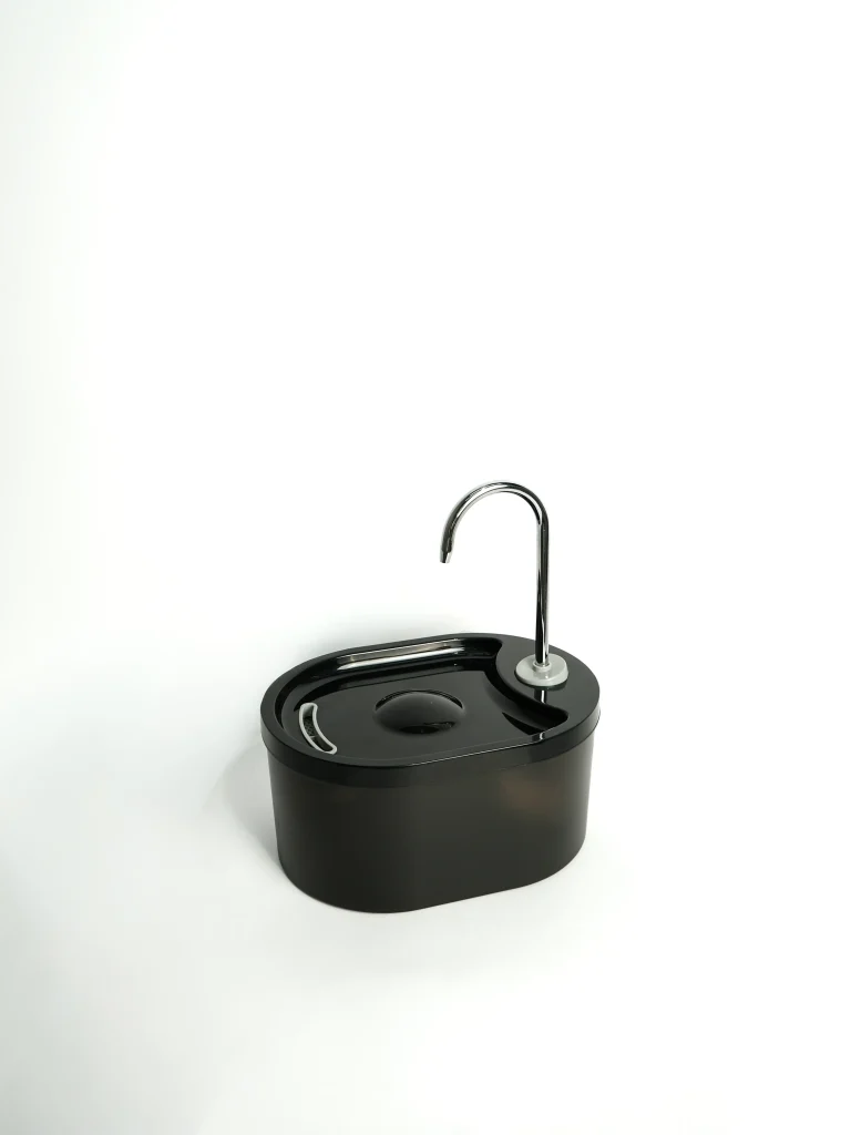 Close-up of the quiet-operation water stream on the white pet fountain, mimicking a natural household tap.