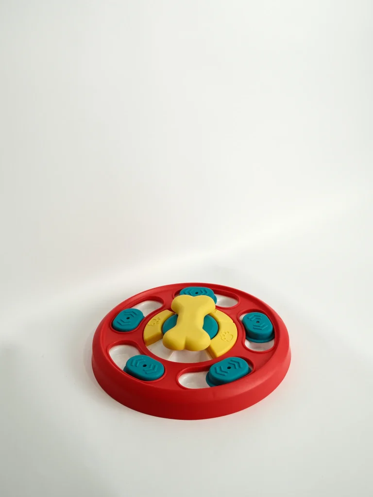 A durable Dog Puzzle Feeder Toy with various circular and square sliding parts to help slow down fast eaters.