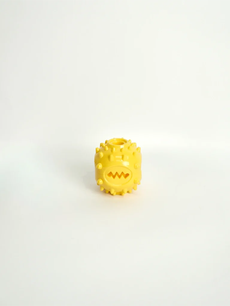 A dog chew and feeder toy in a bright color, designed with grooves to hold soft treats and peanut butter.